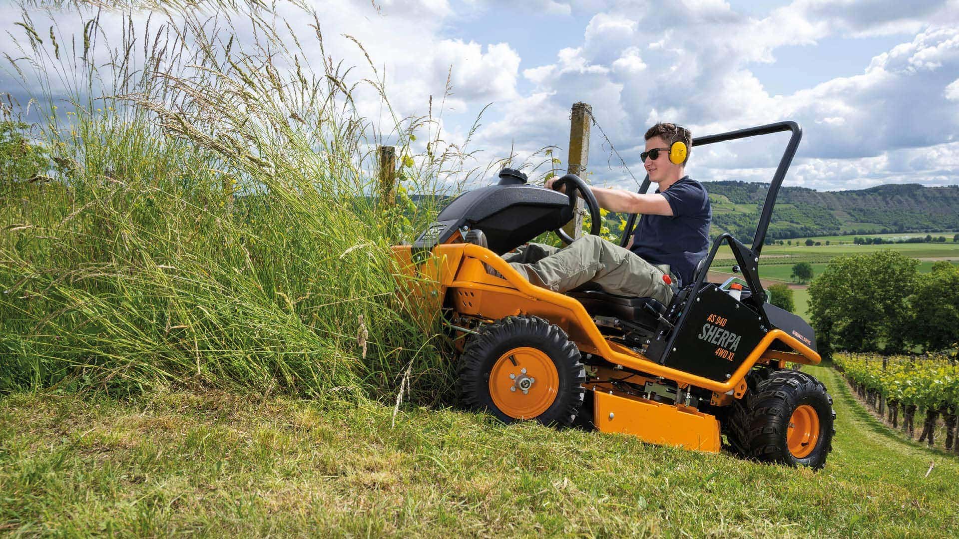 Lawn tractor trimming weeds